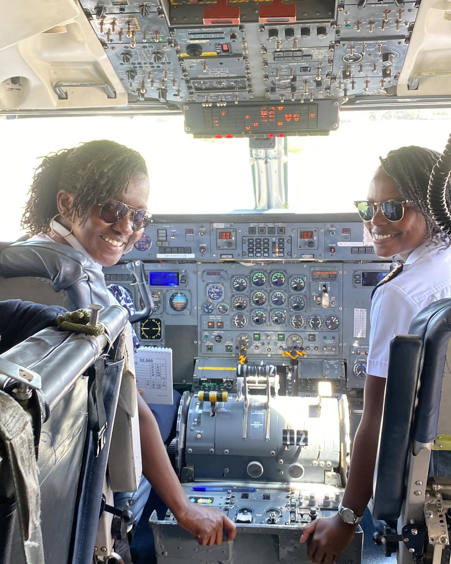 Two Safarilink pilots smiling in the flight deck of a Dash 8