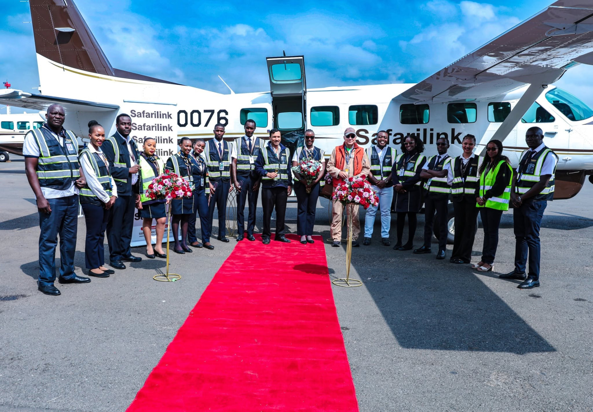 Safarilink team lined up on a red carpet beside a new Cessna Caravan